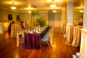 The University Masonic Ballroom prepared for a formal event in shiny gold and eggplant hues